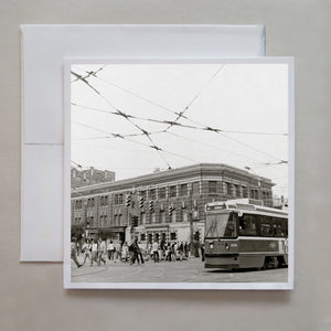 This is a black and white, 6x6, film photograph in Toronto circa 2010 showing a street car and pedestrians on Queen Street West by photographer Caley Taylor.